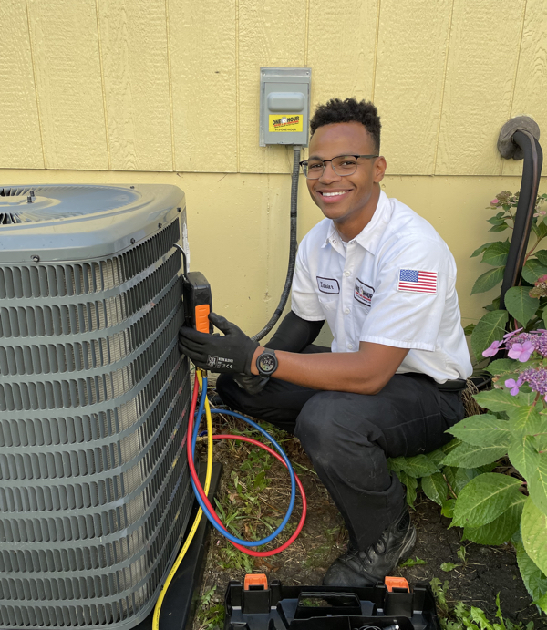 One Hour Heating and Air Conditioning technician with air conditioner